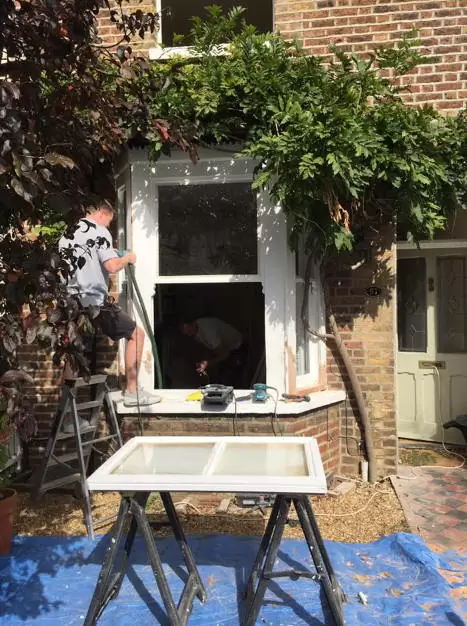 Draught proofing windows in Reigate men working